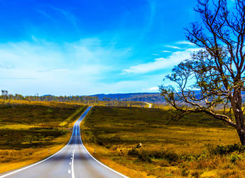 Empty road along countryside landscape