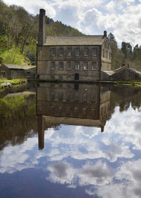 Reflection of building in lake against sky