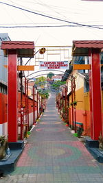 Footpath amidst buildings in city against clear sky