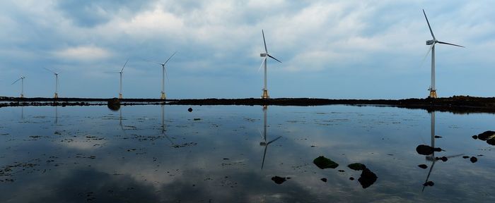 Flock of traditional windmill against sky