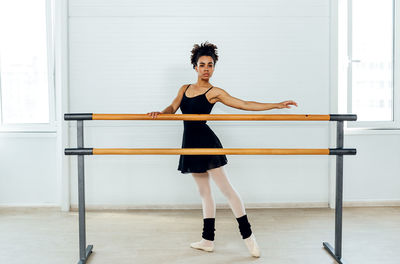 Full length portrait of young woman standing outdoors