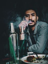 Portrait of young man smoking outdoors