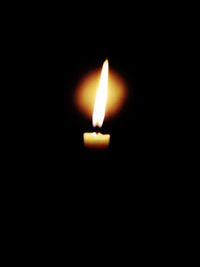 Close-up of lit candle in dark room