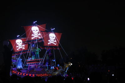 Low angle view of illuminated ferris wheel against sky at night