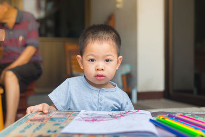 Portrait of cute boy sitting on table