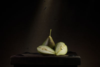 Close-up of pear on table against black background