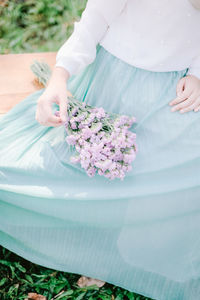 Midsection of woman holding flower bouquet