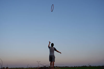 Rear view of man standing against clear sky