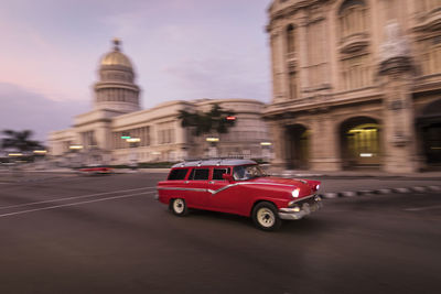 Vintage car on street against buildings in city