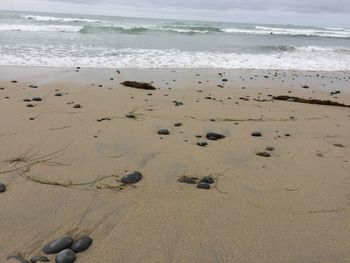 Pebbles on beach against sky