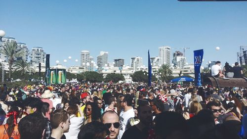 People on street in city against clear sky