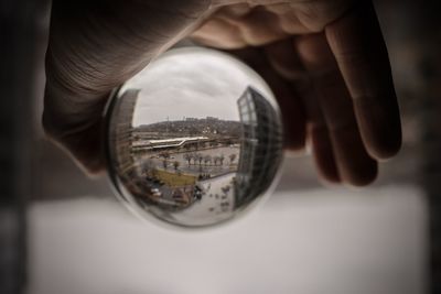 Close-up of hand holding glass with reflection