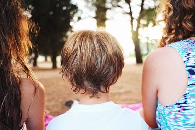 Rear view of mother and daughter against trees