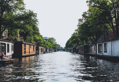 Canal amidst buildings against sky