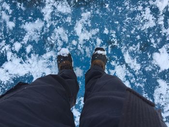 Low section of man standing on snow