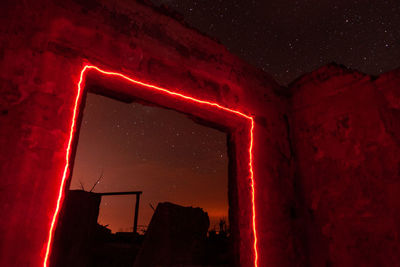 Low angle view of illuminated building against sky at night