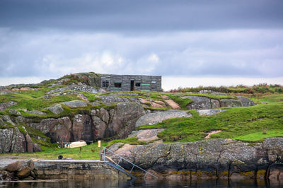 Building by rocks against sky