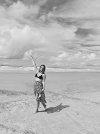 Full length of woman on beach against sky