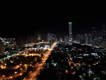 Illuminated cityscape against sky at night