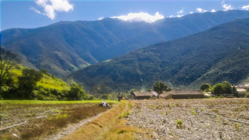 Scenic view of field and mountains against sky