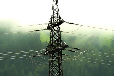 Low angle view of electricity pylon against clear sky