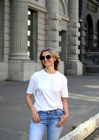 Portrait of young woman standing in city