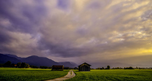 Scenic view of field against cloudy sky