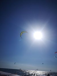 People flying over sea against sky