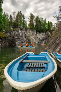 Boats moored on lake against sky