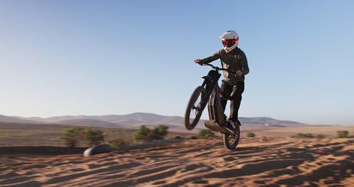Rear view of man riding bicycle on mountain
