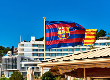 Flag against blue sky in city