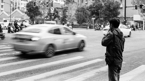 Rear view of people crossing street