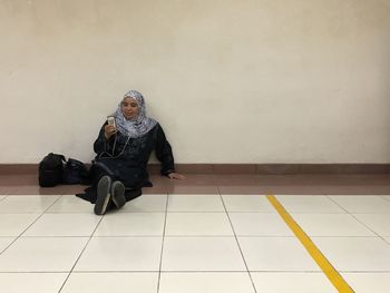 Portrait of young woman sitting on floor