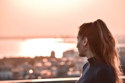 Portrait of woman looking at sea during sunset