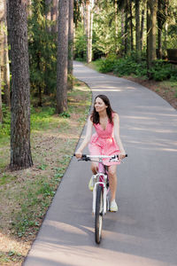 Portrait of young woman riding bicycle on road