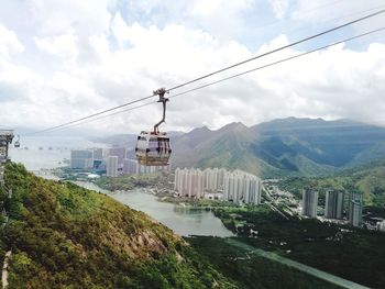 Overhead cable car over mountains against sky