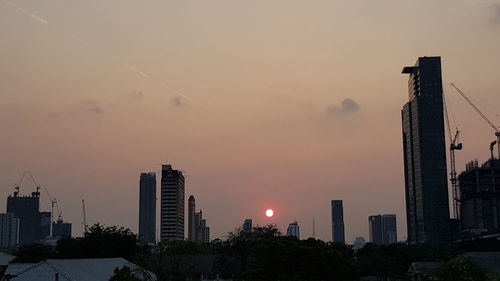 Modern buildings against sky during sunset