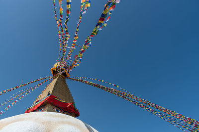 Boudha stupa, at kathmandu city in nepal against blue sky, with religious colorful flags waving.