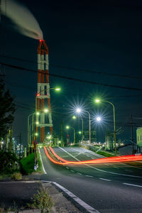 Light trails on road against sky at night