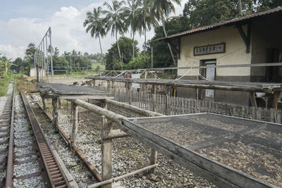 Railroad tracks by swimming pool against sky