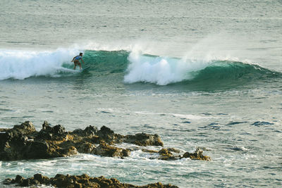 Rear view of man surfing in sea