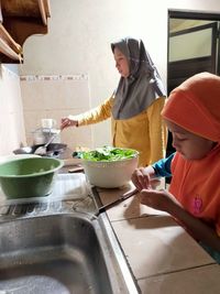 Side view of people having food at home