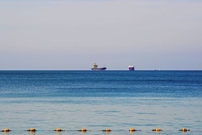 Boat sailing in sea against clear sky
