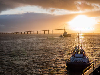 Bridge over sea against sky during sunset