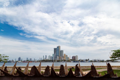 View of cityscape against cloudy sky