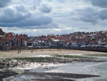 View of town by sea against sky