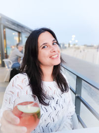 Portrait of young woman drinking glass