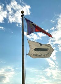 Low angle view of flags sign against sky