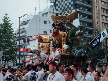 People on street against buildings in city