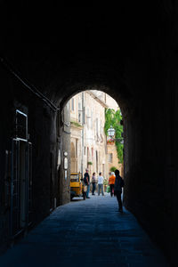 People walking on road amidst buildings in city